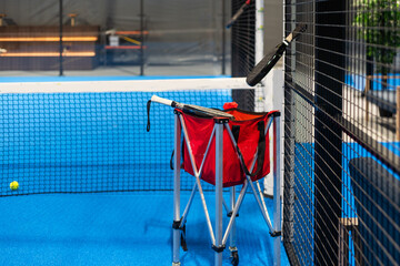 Paddle tennis rackets, balls and basket in court still life