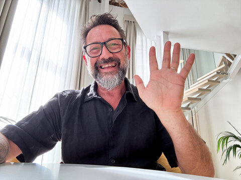 Cheerful adult man enjoy videocall using laptop. Web camera view. Gesturing and smiling with friends online. Happy business solution. Modern worker video call team. Smart working happiness freedom