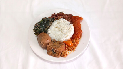 Traditional Gudeg Dish with Egg, Cassava Leaves, and Hot Spicy Krecek on White Plate