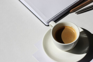Business Meeting Coffee Break. Cup of Espresso, Notebook and Stationery on White Background. Workplace.