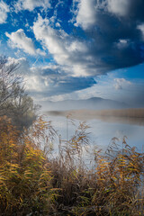 Scenic river landscape adorned with misty fog and captivating clouds