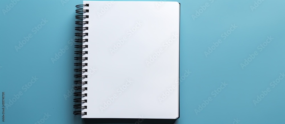 Poster A black notebook placed by itself against a blue backdrop leaving ample space for additional images or text