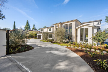 Vast driveway leading towards a serene landscape of trees and shrubs