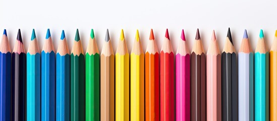 A vibrant arrangement of colorful pencils and crayons on a pristine white background creating a captivating copy space image