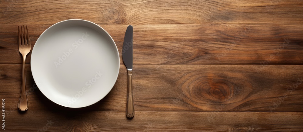 Poster an eating concept is depicted in the image of a spoon and fork alongside a white dish placed on a wo