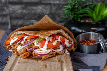 Turkish kebab with chicken doner meat on a wooden board.