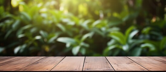 A wooden table on a deck with a background of blurred foliage creates a copy space image