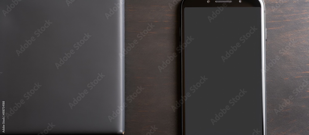 Aufkleber Top view of a Black smart phone and a black power bank being charged on a paper background with copy space image available