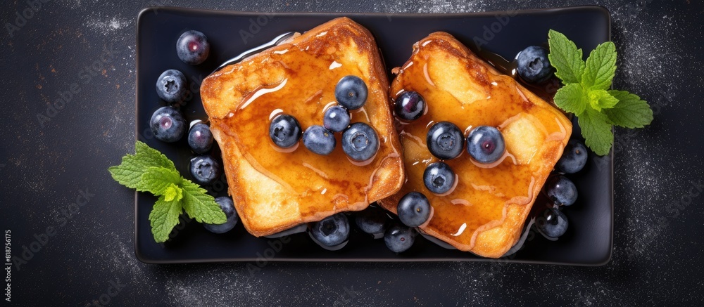 Aufkleber top view of french toasts embellished with maple syrup and blueberries presented on a dark backgroun