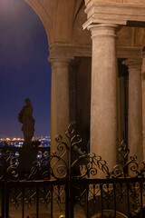 columned porch with statue at night
