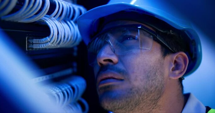 Man, engineer and cables in server room with information technology for hardware in night with helmet. Cybersecurity system, it network and person for fiber internet, goggles and safety with hardware