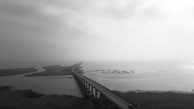 Drone grayscale footage of Alekseevsky Bridge over the Kama River with cloudy sky