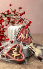 Closeup shot of heart-shaped chocolate candies, adorned with red berries