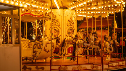 a merry go round with lights lit up in the evening © Wirestock