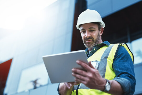 Tablet, engineer and man with helmet on construction site for development or building in city on project. Male person, tech and architecture as manager for progress in industrial, design and safety
