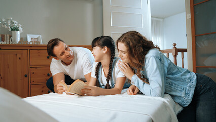 Bedtime story with childhood storytelling, mom and dad reading a fantasy book together to their...