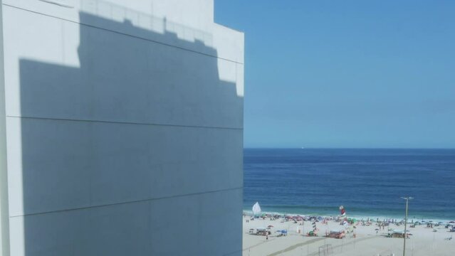 Timelapse of shadow from building moving on wall with Leme beach background in Rio de Janeiro, Brazi