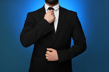 Businessman in suit and necktie on blue background, closeup