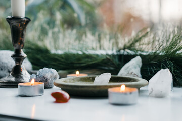 a close up of a candle on top of a table with rocks