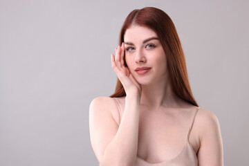 Fototapeta premium Portrait of beautiful woman on grey background. Space for text