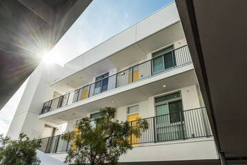Fototapeta premium Sun peaking through an apartment building on a sunny afternoonsunny