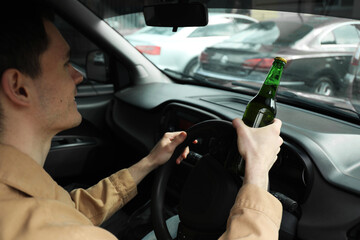 Man with bottle of beer driving car. Don't drink and drive concept