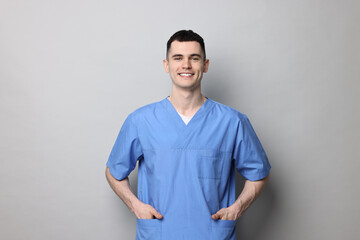 Portrait of smiling medical assistant on grey background