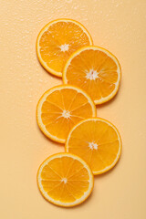 Slices of juicy orange and water on beige background, flat lay