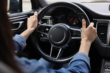 Woman holding steering wheel while driving her car, closeup