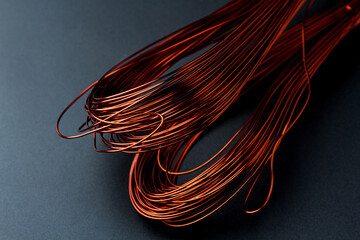 A coil of copper wire on a black background.