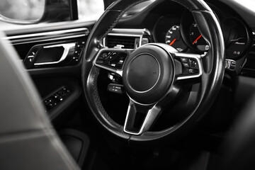 Steering wheel inside of modern black car, closeup