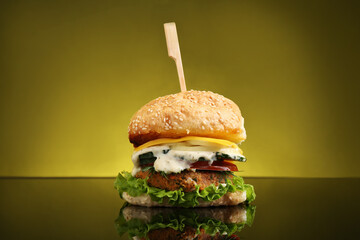 Delicious vegetarian burger on mirror surface against olive background