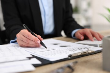 Secretary doing paperwork at table in office, closeup