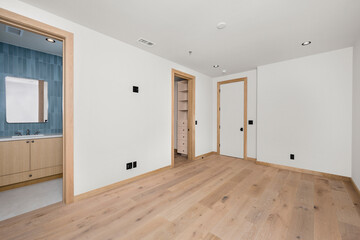 a hallway with an unfinished door and a wood floor in it