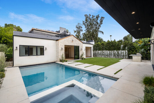 an outdoor pool sits in the middle of a large backyard
