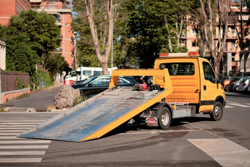Evacuation Tow Truck Vehicle With Lowered Flatbed Ramp In Action Outdoors