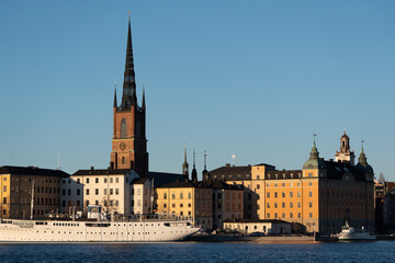 Fototapeta premium Massive white boat floating gracefully amidst a bustling waterfront cityscape