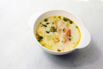 Finnish creamy soup with salmon on the wooden table