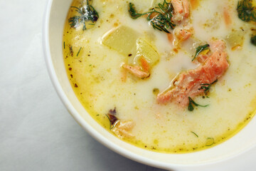 Finnish creamy soup with salmon on the wooden table