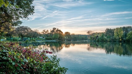 Obraz premium Sunset illuminates trees and bushes near water