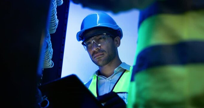 Data center, teamwork and man with computer in server room for programming, coding and information technology. Cybersecurity, IT and technicians on tablet for inspection, maintenance and software