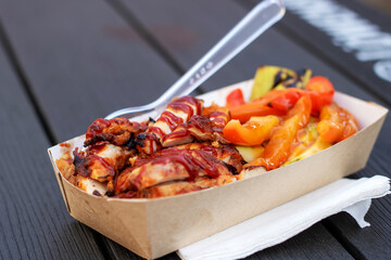 Fast food container with chicken, vegetables, and fork for convenience