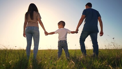 family walking park together. The family silhouette walking on the sunset is a stunning representation of the beauty of nature. happy family kid dream concept lifestyle