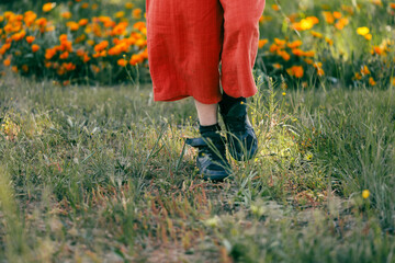 Feet only image of girl walking in field of wildflowers