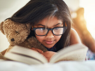 Kid, girl and reading book for home learning, education or story with glasses for knowledge and...