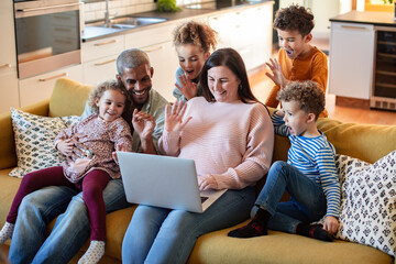 Happy diverse family enjoying time together with laptop at home