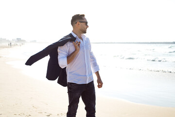 Young businessman on the phone at beach. Freedom, vacation or stress free concept
