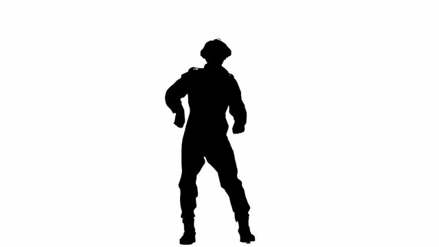 Black silhouette of a man in overalls dancing merrily. An unrecognizable man with curly hair poses against a white isolated background.