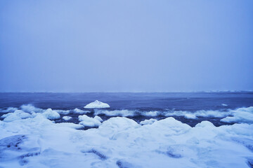 Beautiful winter landscape featuring floating ice and sea waves against the blue sky backdrop