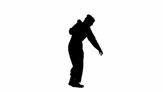 Black silhouette of a maniacal man in overalls walking with a knife in his hand and looking around. Unrecognizable man with curly hair on white isolated background. Side view.